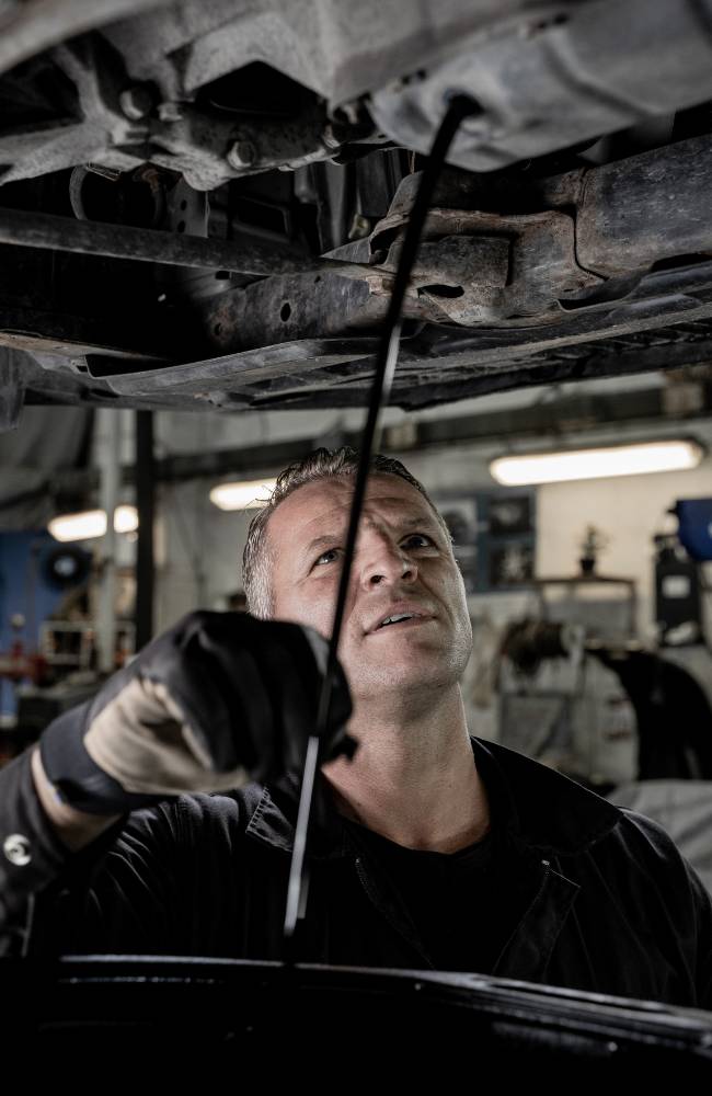 Welcome Automotive technician working on a vehicle in the bay